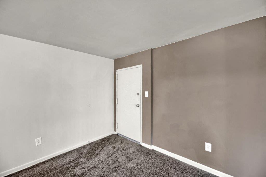 the living room of an empty house with a door